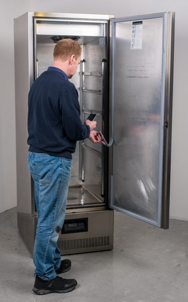 Man changing fridge seals in a commercial kitchen 