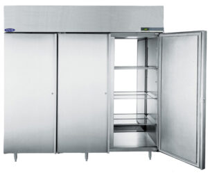 Tips for a healthy fridge 1 A large, three-door commercial stainless steel fridge stands on metal legs. One door is open, revealing multiple wire shelves inside, while the other two doors are closed. The appliance has a digital display panel on the upper right side.