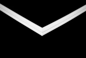 The Trimco BRABANT SG H features a white, V-shaped frame corner that contrasts boldly with a solid black background, creating a symmetrical, geometric look with clean lines and sharp angles.